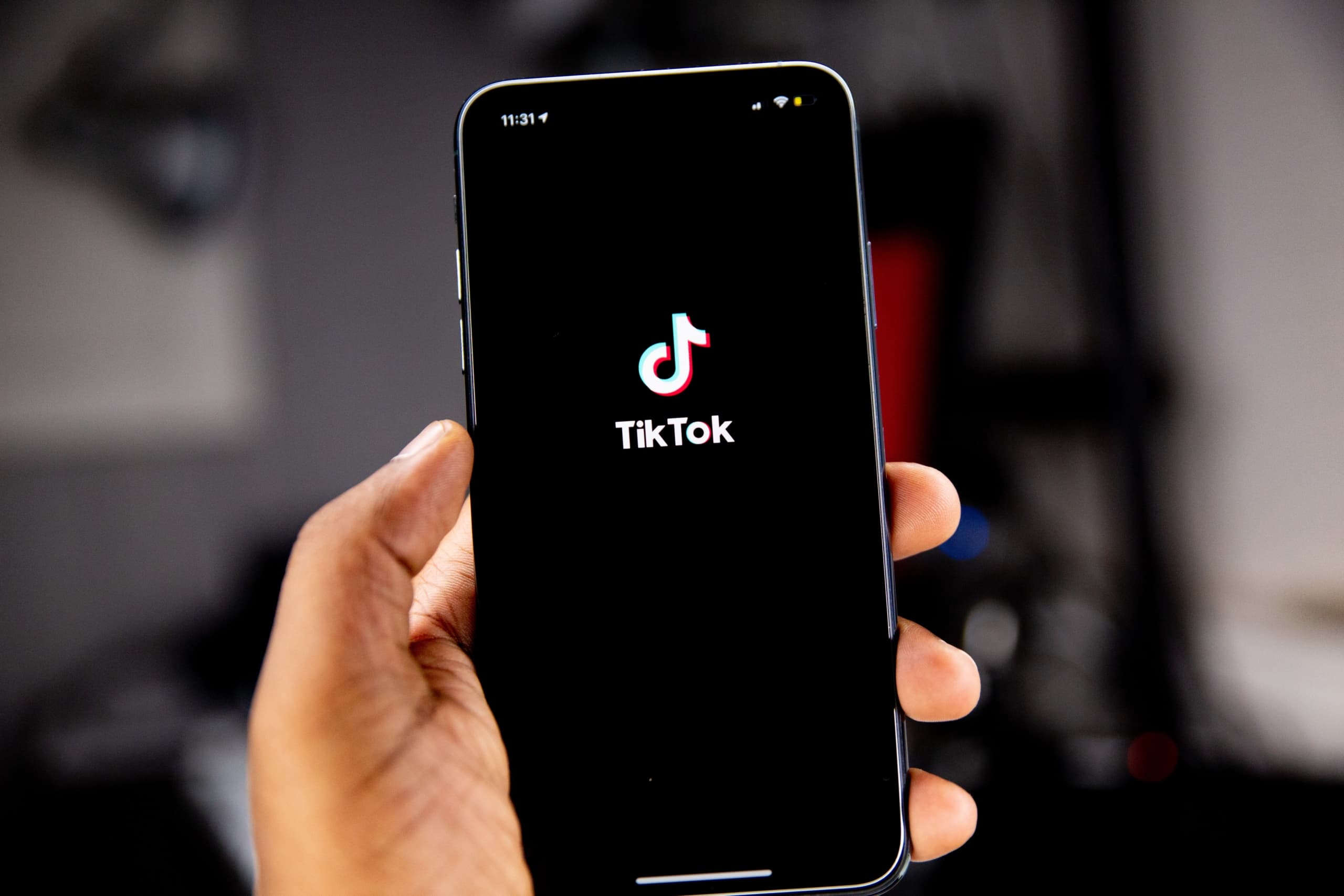 TikTok logo on a phone held in a hand
