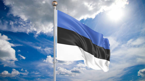 Colored waving flag of Estonia on sunny blue sky background.